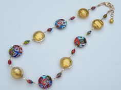 "Millefiori Murano Venetian Glass Bead Necklace; adjustable length, 19 inches to 21 inches with gold filled link chain, and gold filled, large, lobster style spring clasp. I designed this multicolored, mosaic, fine millefiori necklace with 24 karat gold foil beads, to make an outstanding combination. Millefiori translates from Italian to English to mean \"thousand flowers\". Fine Millefiori: Each handmade bead is the finest Millefiori made in Murano. The Murano artisan smooths and polishes each Adjustable Murano Glass Necklace, Adjustable Round Murano Glass Necklace, Adjustable Gold Murano Glass Necklaces, Italian To English, Murano Glass Necklaces, 24 Karat Gold, Bugle Beads, Venetian Glass, Handmade Beads