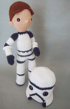 a crocheted star wars character next to a small white stuffed toy on a gray background