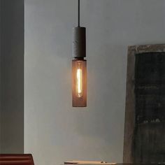 a light that is hanging from the ceiling above a table with a book on it