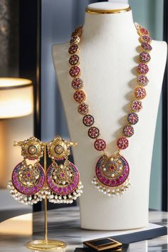 Step into the extravagant fusion of grace and royalty with the "Adiva - Long Mala Necklace Set." This opulent set paints you in luscious shades of multi-color stones and embellishments, elevated by pearl moti hangings. It features a classic embodiment of a beautiful flower motif design that exudes elegant femininity.The set includes a beautifully crafted mala with an adjustable dori for a perfect fit and a pair of dangle earrings, each designed to enhance your regal charm. With an approximate ma Elegant Multicolor Temple Necklace For Celebration, Multicolor Gemstone Jewelry For Parties, Elegant Multicolor Temple Necklace For Diwali, Festive Gemstone Jewelry Sets For Celebration, Multicolor Gemstone Party Jewelry, Formal Multicolor Jeweled Necklaces, Multicolor Jeweled Kundan Necklace In Fusion Style, Multicolor Temple Jewelry Necklace, Multicolor Fusion Style Temple Necklace With Meenakari