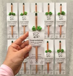 a hand is holding several pencils in front of each other with clover decorations on them