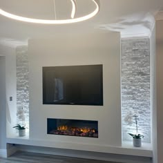 a living room with a large flat screen tv mounted on the wall and a fire place