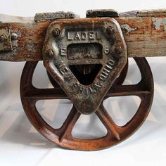 an old wooden wagon wheel with the word lace on it's center and two metal wheels