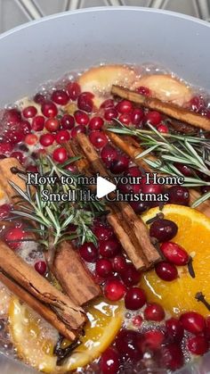 a pot filled with oranges, cinnamon sticks and cranberries