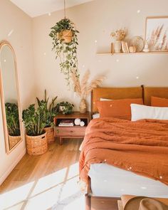 a bed room with a neatly made bed next to a mirror and potted plants