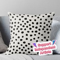 a black and white polka dot pillow with the words support independent artists in pink on it