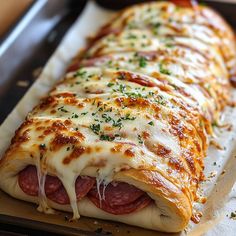 a long pizza with cheese and meat on it