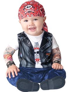 a baby wearing a bandana sitting on the ground