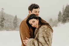 a man and woman are hugging in the snow