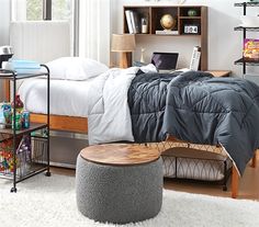 a bed room with a neatly made bed and a laptop on a desk next to it