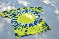 a yellow and black tie - dyed shirt laying on the ground