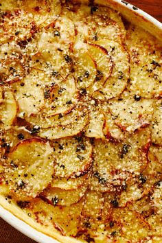 a casserole dish with potatoes and parmesan sprinkles on top