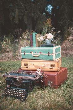 a bunch of suitcases stacked on top of each other in front of a typewriter