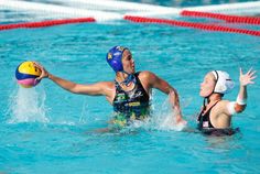 two women playing water polo in the pool