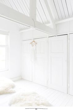 a bedroom with white walls and flooring is featured in this postcard style photo