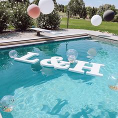 balloons floating in the air over a pool with an h & m sign on it