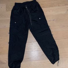 Black, Vinyl Material, Baggy Cargo Pants. Very Light Weight And Comfortable. Never Worn. Black High-waist Parachute Pants With Pockets, Black High Waist Utility Parachute Pants, High Waist Black Parachute Cargo Pants, Casual High Waist Black Parachute Pants, Casual High-waist Black Parachute Pants, Black Utility Bottoms With Cargo Style, Black Utility Cargo Bottoms, Black Utility Cargo Style Bottoms, Black Utility Cargo-style Bottoms