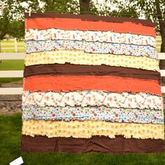 a large quilt hanging on the side of a fence