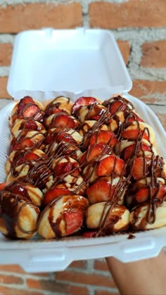 a white container filled with strawberries and chocolate drizzled on top of it