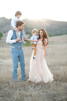 a man, woman and child standing in a field