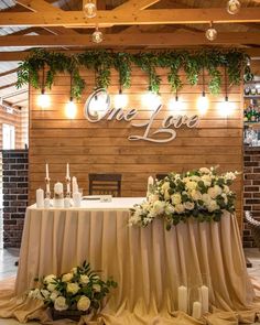 a table with flowers and candles on it in front of a sign that says one love