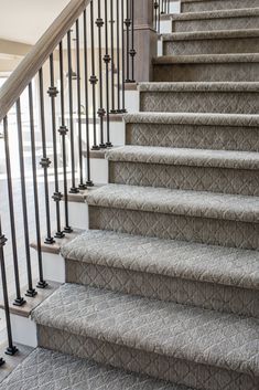 an image of a staircase with carpet on the bottom and handrails above it