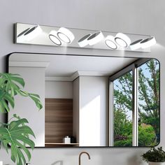 a bathroom mirror with three lights above it