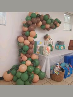 balloons are arranged in the shape of a letter on a table with other items around it