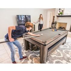 two people are playing pool in the living room