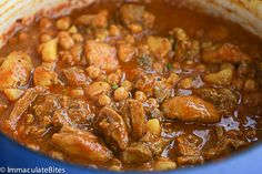 a blue pot filled with meat and beans