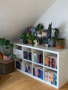 a book shelf with books and plants on it