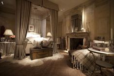 a bed room with a neatly made bed next to a fire place and a fireplace