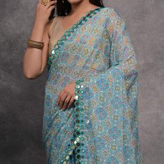 Blue colored saree is made from georgette fabric which is highlighted with beautiful bandhani printed mirror work as shown. Comes along with unstitched heavy satin gota blouse piece which you can customise as per your design/style. Occasion - You can wear this saree for casual and daily wear. Note:- the actual product may differ slightly in color and design from the one illustrated in the images when compared with computer or mobile screen. Measurements: Saree : Georgette : 5.5 Mtrs Blouse : Geo Unstitched Bollywood Saree With Mirror Work, Blue Chanderi Pre-draped Saree With Motifs, Unstitched Pre-draped Saree With Mirror Work For Navratri, Bollywood Style Saree With Mirror Work For Eid, Multicolor Mirror Work Pre-draped Saree For Navratri, Bollywood Style Semi-stitched Saree With Mirror Work, Bollywood Style Saree With Mirror Work For Diwali, Blue Unstitched Sharara With Bandhani Print, Blue Bandhani Print Chanderi Sharara