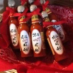 six hot sauce bottles with the words still hot at 40 written on them in black ink