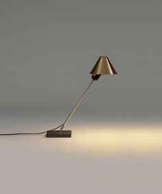 a lamp that is on top of a white surface with light coming from the base