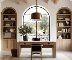 an arched window in a home office with wooden desk and bookcases on either side