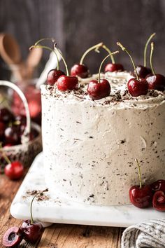 a cake with cherries on it sitting on top of a wooden table