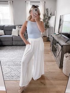 Our Elaine Linen Wide Leg Pants features an ivory hued material, high waisted fit with elastic waistline, side pockets, wide leg with cropped hemline. Inseam: 24.5" approx. Nude undergarments recommended. Model is 5'1", 34D, 6/28 and is wearing a size small. Item runs true to size in top with generous stretch and pants are relaxed - set sold together. More details: 25% linen 25% rayon. hand wash or wash on cold and hang to dry.