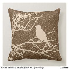 a pillow with a bird sitting on a branch