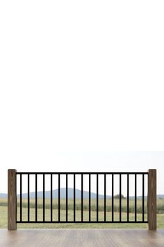 an empty balcony with wooden flooring and black iron railings, overlooking the countryside