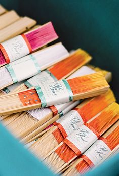 many different colored paint brushes in a blue container