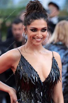 an image of a woman that is smiling for the camera and wearing a dress with fringes on it