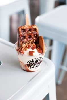 an ice cream sundae with nuts and cinnamon on top sits on a white table