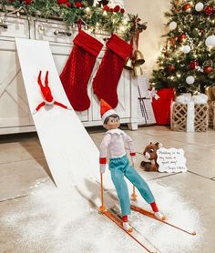 a doll is posed on skis in front of a christmas tree