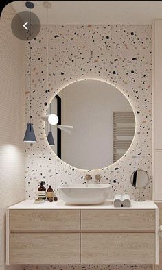 a bathroom with a large round mirror above the sink and lights hanging from the ceiling