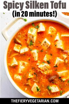 a white bowl filled with tofu soup and topped with parsley on the side