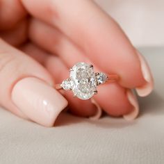 a woman's hand holding an engagement ring