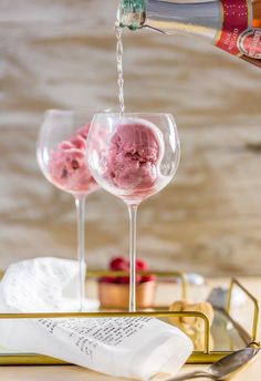 two wine glasses with ice cream being poured into them