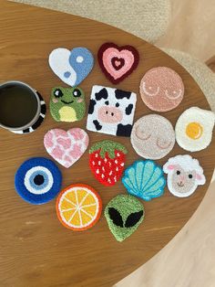 a wooden table topped with lots of different types of magnets next to a cup of coffee