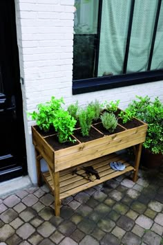 a wooden planter filled with plants next to a building